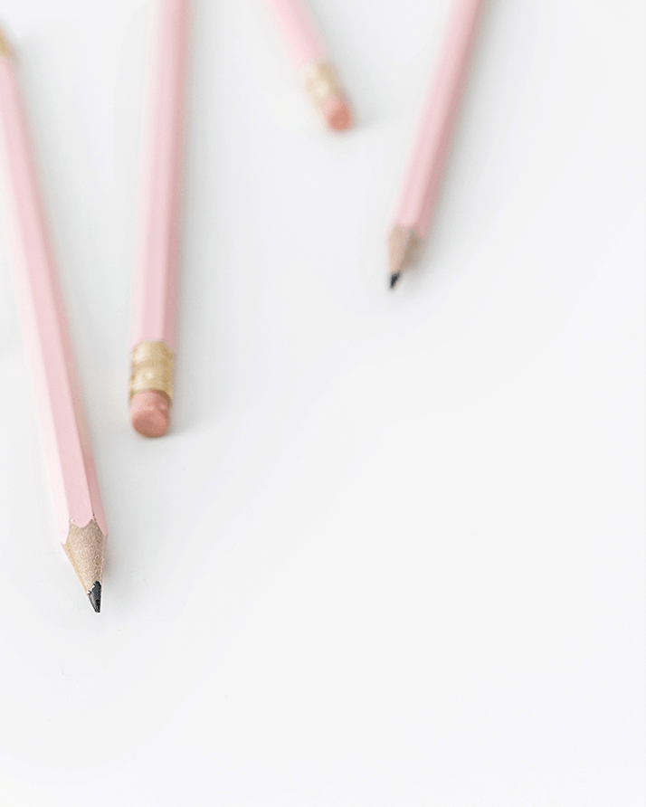Four pink pencils on a white surface